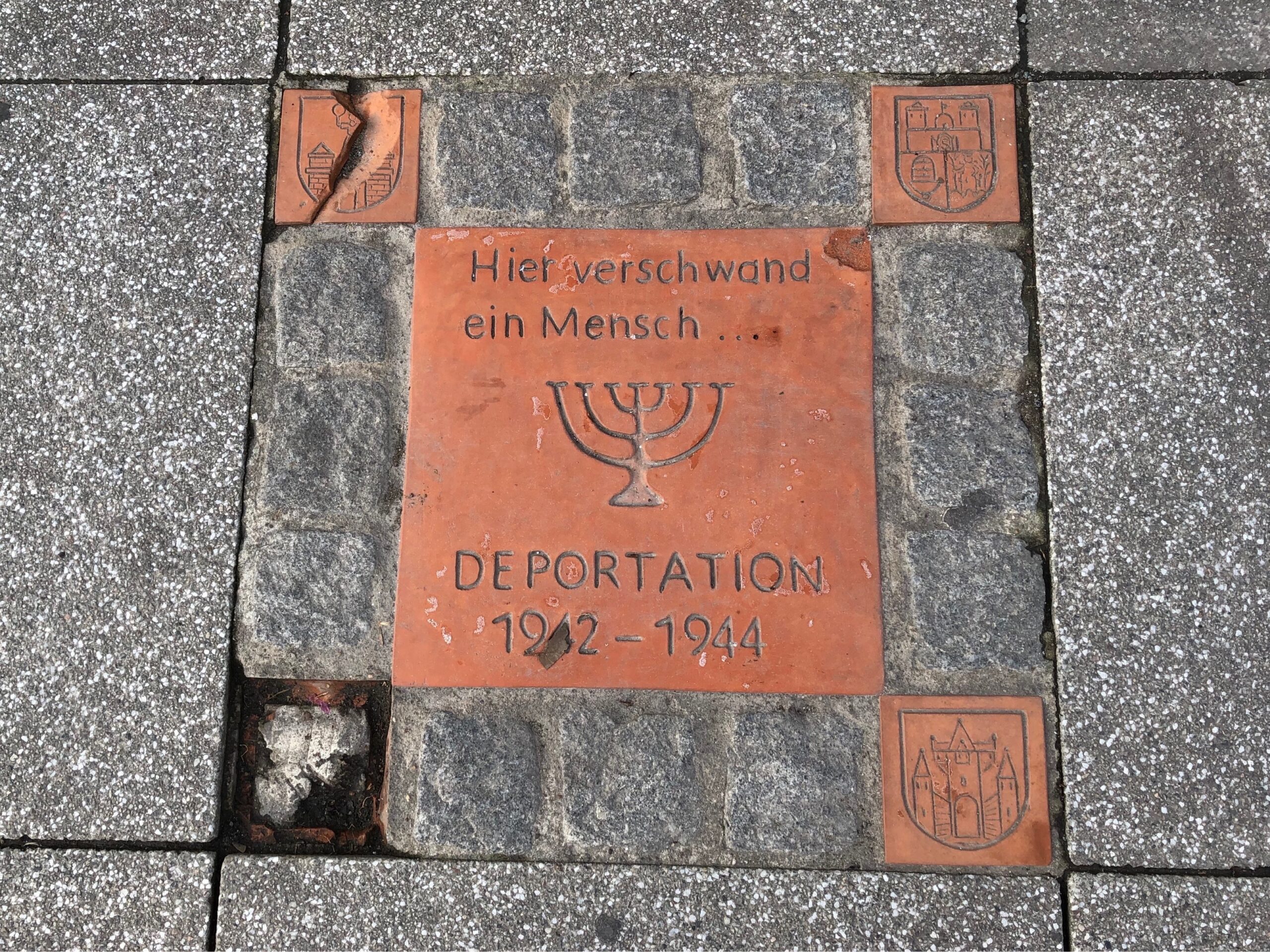 In den Gehweg eingelassene Gedenkplatte mit der Inschrift "Hier verschwand eine Mensch ... Deportaion 1942 - 1944"